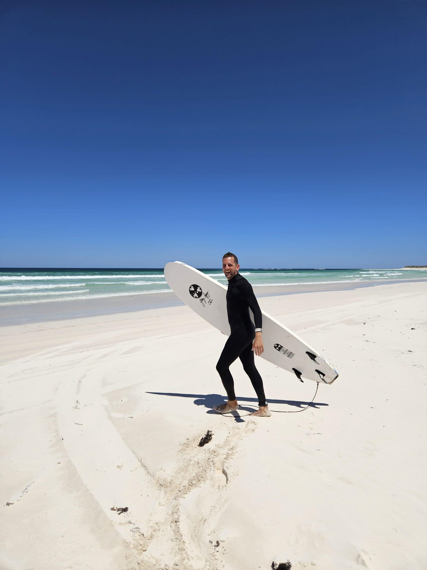Johannes on the beach with a surfboard